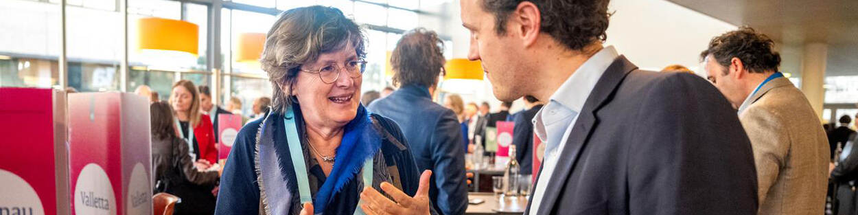 Ambassadeur in gesprek met ondernemer tijdens de bedrijvendag van de Ambassadeursconferentie.