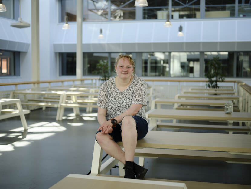 Maaike van de Jagt zit op een tafel in de kantine van Hogeschool Windesheim