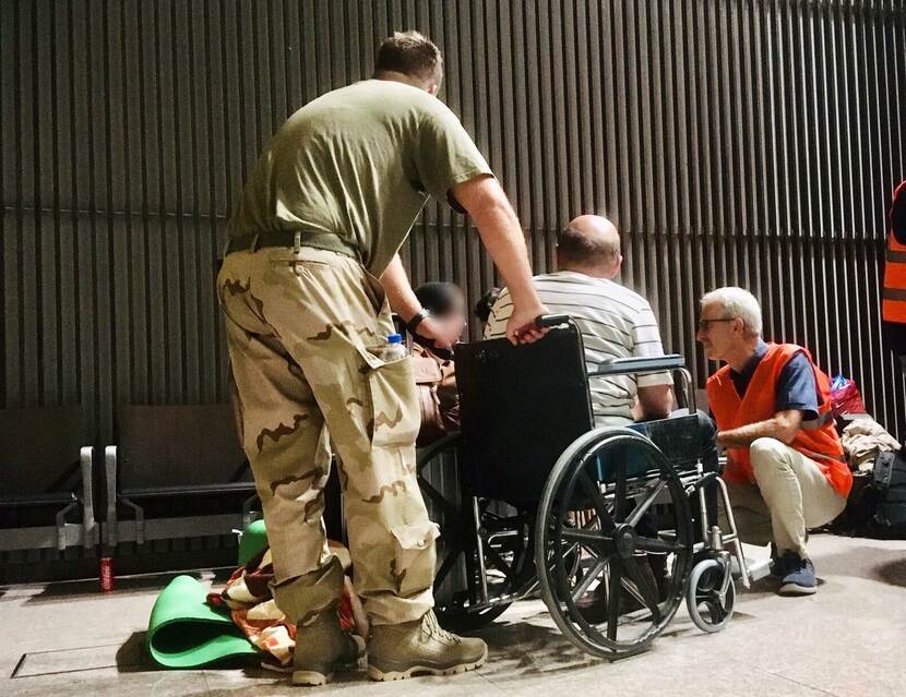 Ambassadeur Wouter Plomp praat met een evacue op de luchthaven van Islamabad BLUR