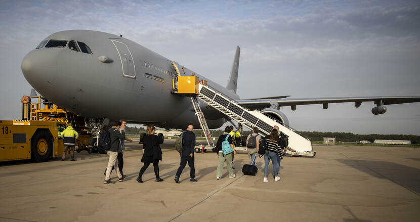 Mensen lopen naar een vliegtuig.