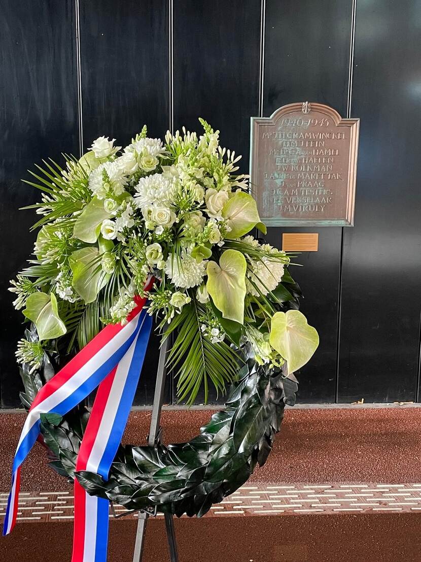 Bloemenkrans voor gedenkplaat op muur