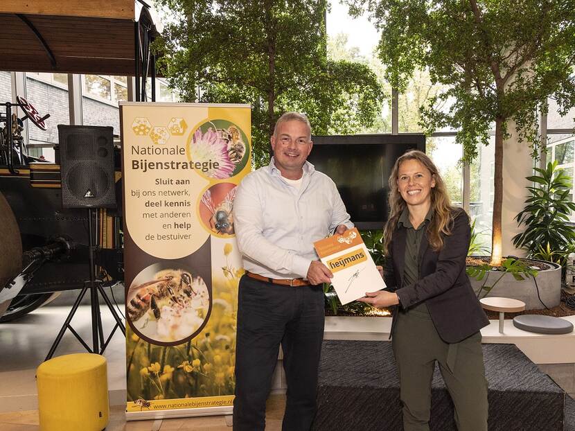 Nicky Kruizinga van de NBS overhandigt partnerbord aan CFO Heijmans Gavin van Boekel